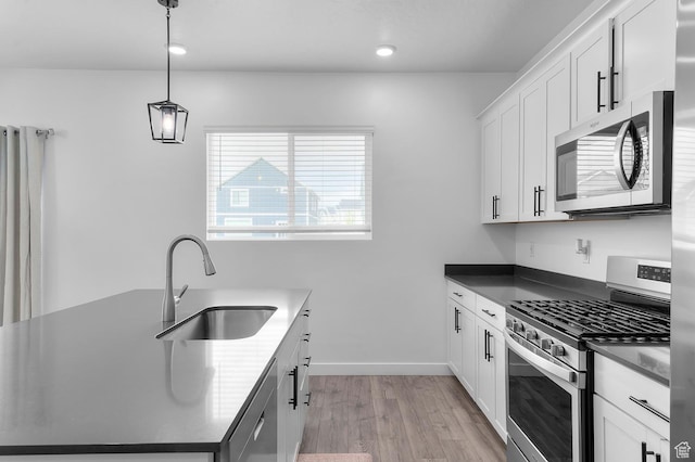 2607 N Mclaws Ave, Layton, UT 84040 - kitchen with appliances with stainless steel finishes, a sink, light wood-type flooring, white cabinets, and dark countertops