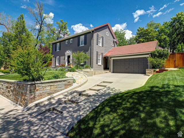 1133 S 1400 E, Salt Lake City, UT 84105 - colonial inspired home with concrete driveway, an attached garage, stucco siding, and a chimney
