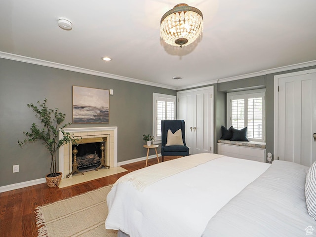 1133 S 1400 E, Salt Lake City, UT 84105 - bedroom featuring ornamental molding, wood finished floors, baseboards, a tile fireplace, and multiple closets