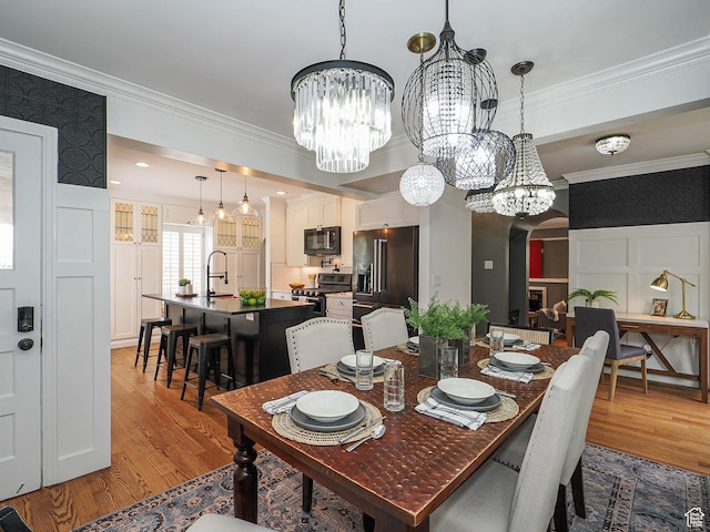 1133 S 1400 E, Salt Lake City, UT 84105 - dining area featuring a chandelier, wood finished floors, ornamental molding, arched walkways, and a decorative wall