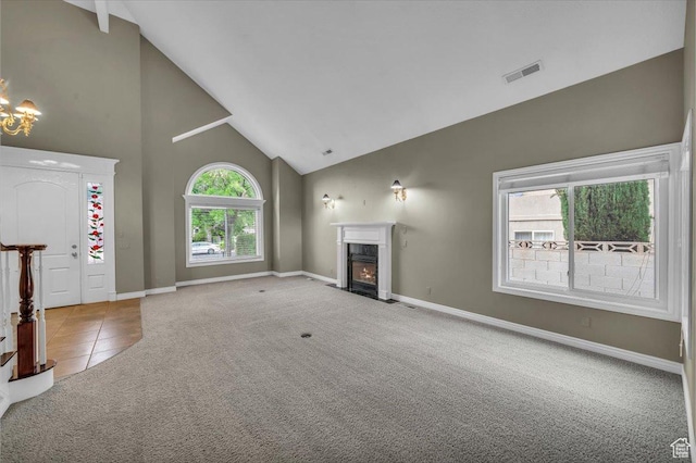 1659 S Cobblestone Ln, St George, UT 84790 - unfurnished living room featuring high vaulted ceiling, carpet, a fireplace, baseboards, and a chandelier