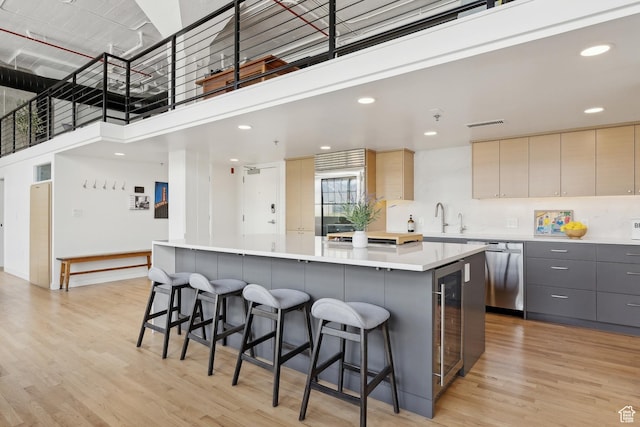 kitchen with dishwasher, gray cabinetry, a large island, modern cabinets, and light wood finished floors