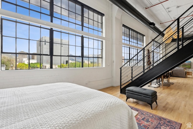 bedroom with wood finished floors and a high ceiling