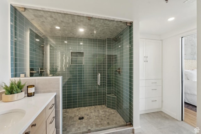ensuite bathroom featuring a shower stall, recessed lighting, vanity, and tile patterned flooring
