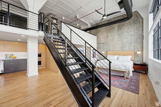stairs featuring wood finished floors and a towering ceiling