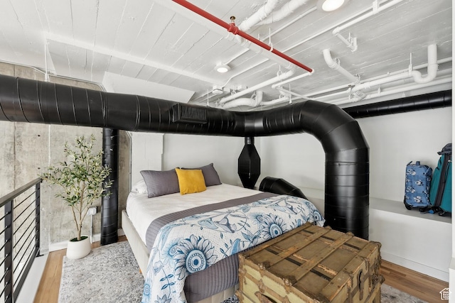 bedroom with wood finished floors and baseboards