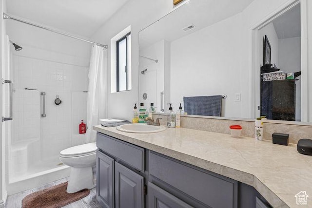 bathroom featuring a shower with shower curtain, vanity, and toilet