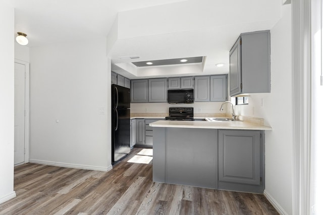 1075 N 1400 W Unit 32, St George, UT 84770 - kitchen with gray cabinets, black appliances, a sink, a tray ceiling, and a peninsula