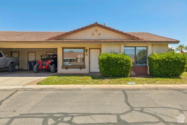 view of front of home with a carport, stucco siding, driveway, and a tile roof