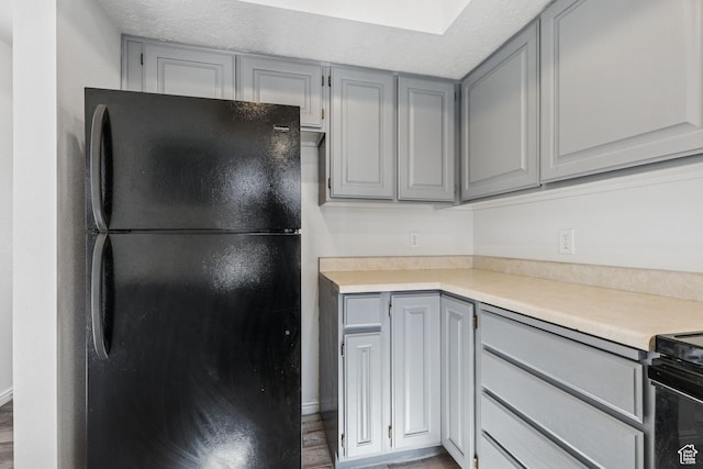 1075 N 1400 W Unit 32, St George, UT 84770 - kitchen featuring freestanding refrigerator, gray cabinetry, light countertops, and wood finished floors