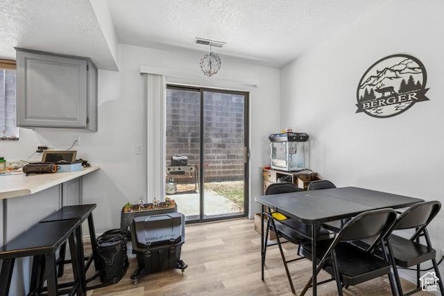 dining room with a textured ceiling and light wood-type flooring
