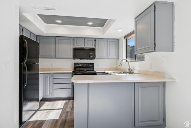 1075 N 1400 W Unit 32, St George, UT 84770 - kitchen featuring black appliances, gray cabinets, a sink, a peninsula, and a tray ceiling