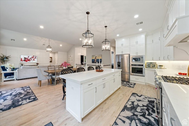 684 S 990 W, Hurricane, UT 84737 - kitchen featuring stainless steel appliances, a kitchen breakfast bar, light wood-style floors, light countertops, and a kitchen island