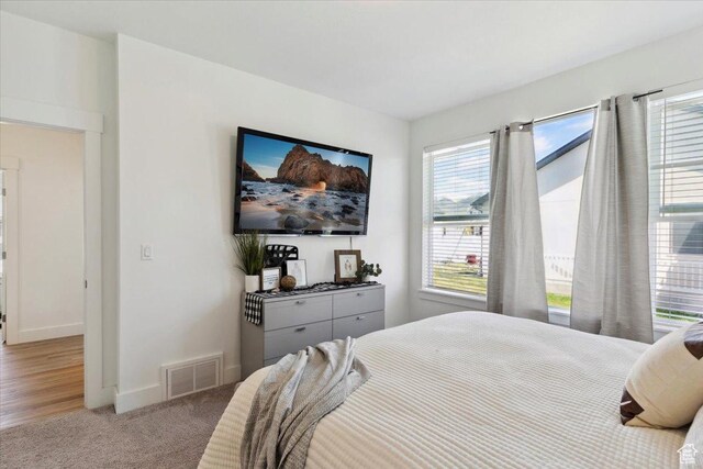 bedroom featuring multiple windows, carpet, and baseboards