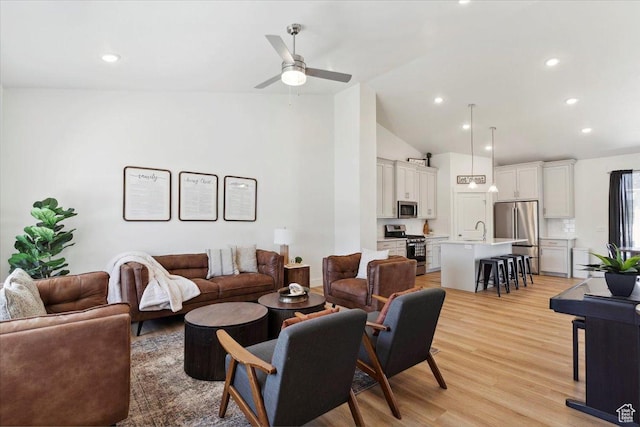 living area with ceiling fan, light wood-style flooring, high vaulted ceiling, and recessed lighting