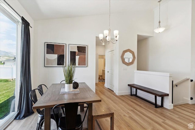 dining area featuring light wood-style flooring, a chandelier, and baseboards
