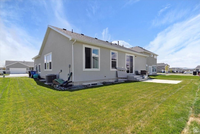rear view of property with central air condition unit, a yard, and stucco siding