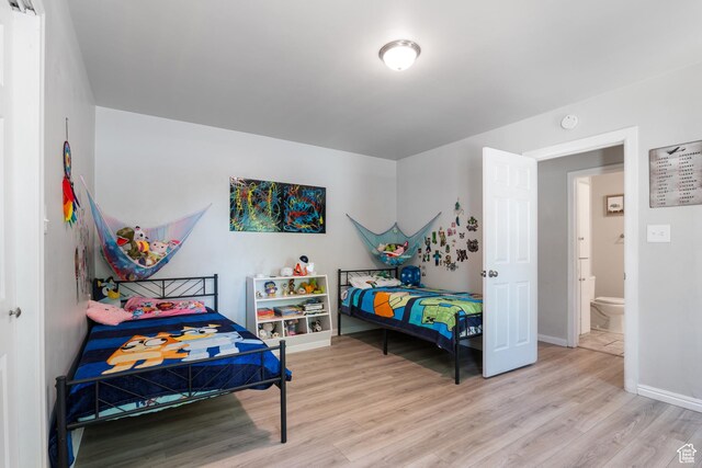 bedroom with light wood-style flooring and baseboards