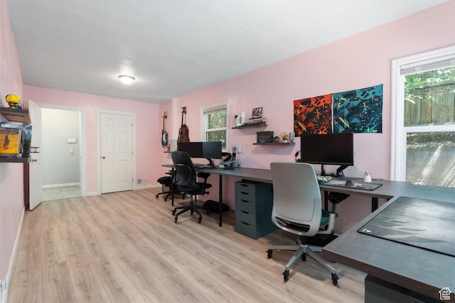 office area featuring light wood-type flooring and baseboards