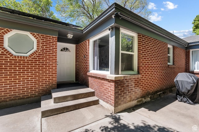 view of side of property with brick siding and a patio