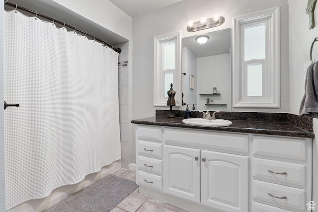 bathroom featuring shower / bathtub combination with curtain, vanity, and tile patterned flooring