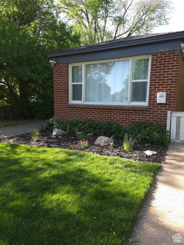 view of front of house with brick siding and a front lawn
