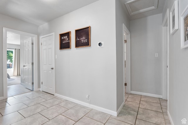 corridor featuring attic access and baseboards