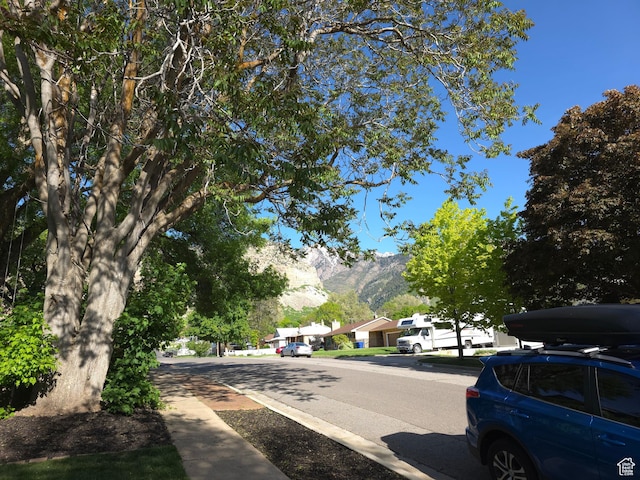 view of asphalt street with a mountain view and sidewalks