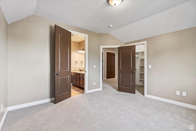 916 Country Ln, Farmington, UT 84025 - unfurnished bedroom with vaulted ceiling, light carpet, a sink, baseboards, and a closet