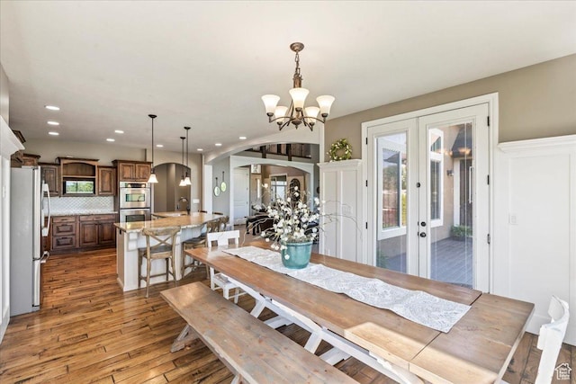 916 Country Ln, Farmington, UT 84025 - dining room featuring arched walkways, recessed lighting, french doors, wood finished floors, and a chandelier