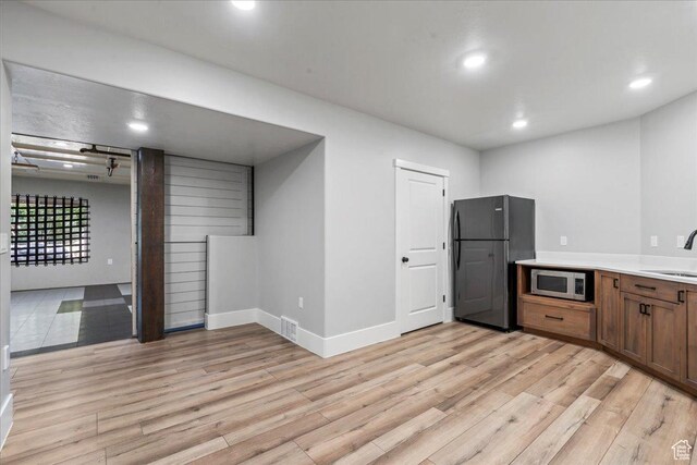 916 Country Ln, Farmington, UT 84025 - kitchen with stainless steel microwave, a sink, light wood-style flooring, freestanding refrigerator, and recessed lighting