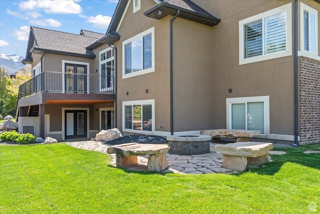 916 Country Ln, Farmington, UT 84025 - rear view of property featuring stucco siding, a fire pit, a balcony, and a lawn