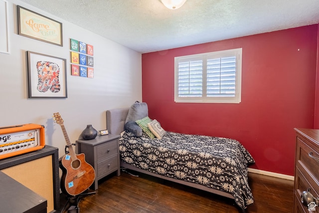 bedroom featuring dark wood-type flooring, a textured ceiling, and baseboards