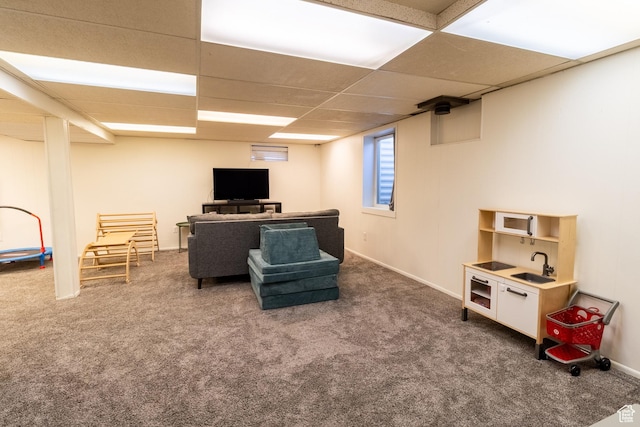 carpeted living area featuring a sink and a paneled ceiling