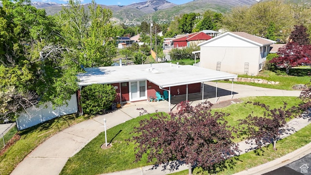 single story home featuring a mountain view, brick siding, and a front yard