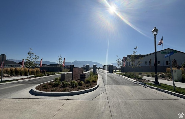 view of concrete street featuring curbs, sidewalks, and a residential view