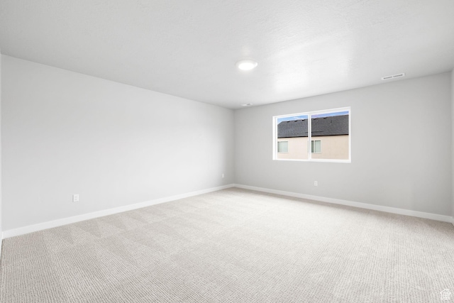 unfurnished room featuring light colored carpet and baseboards