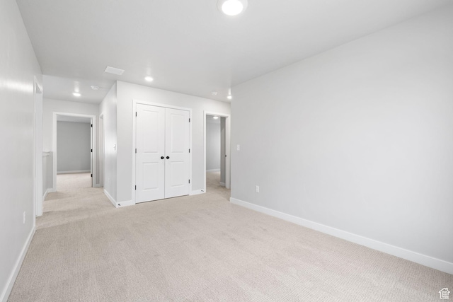 empty room with light colored carpet, baseboards, and recessed lighting