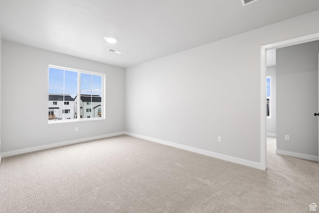 empty room with light colored carpet and baseboards