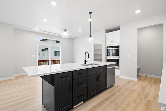 kitchen featuring a sink, stainless steel dishwasher, multiple ovens, light wood-type flooring, and recessed lighting