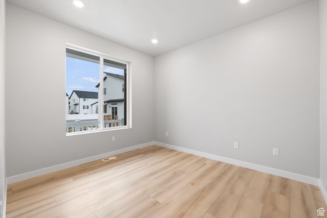 spare room featuring wood finished floors, recessed lighting, and baseboards