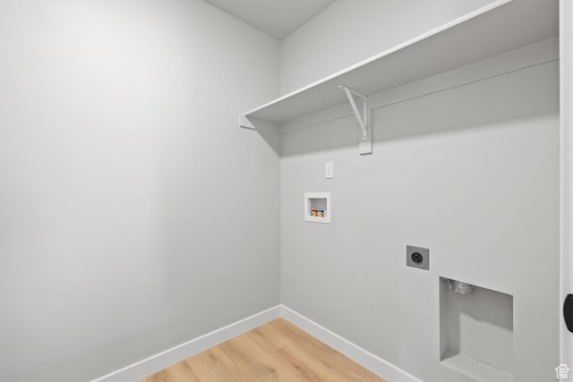 washroom featuring hookup for a washing machine, hookup for an electric dryer, light wood-style floors, and baseboards
