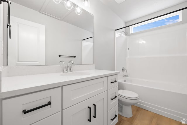 bathroom with wood finished floors, vanity, toilet, and tub / shower combination
