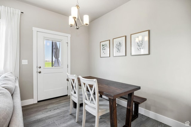 dining area with a chandelier, light wood-style flooring, and baseboards