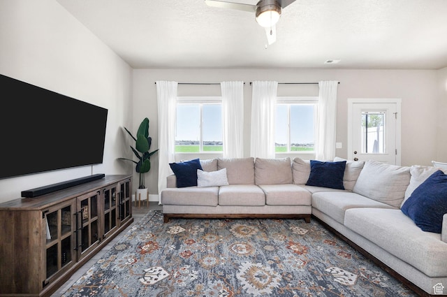 living room with ceiling fan and baseboards
