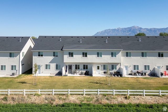rear view of house featuring a patio, a mountain view, and stucco siding