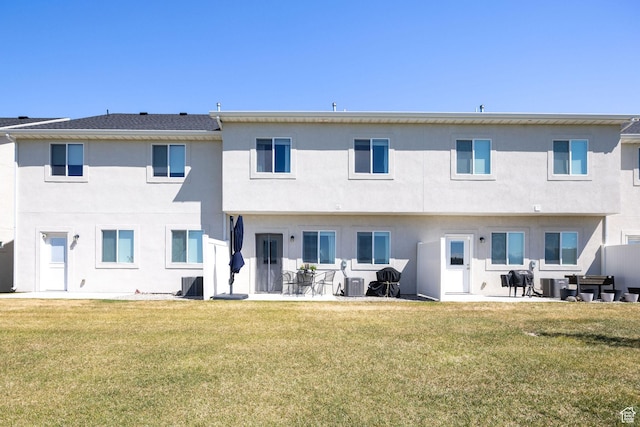 back of property featuring a yard, cooling unit, and stucco siding