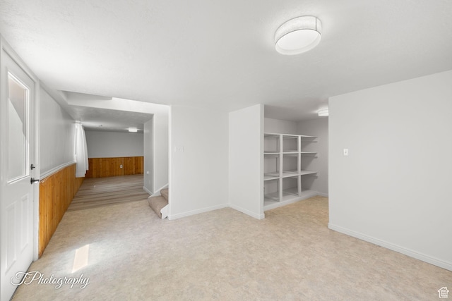 180 N 1100 E Unit 116, Washington, UT 84780 - empty room with wooden walls, a wainscoted wall, stairs, and light colored carpet