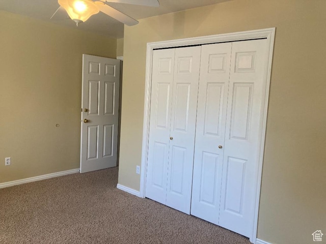 unfurnished bedroom with carpet flooring, a closet, baseboards, and a ceiling fan