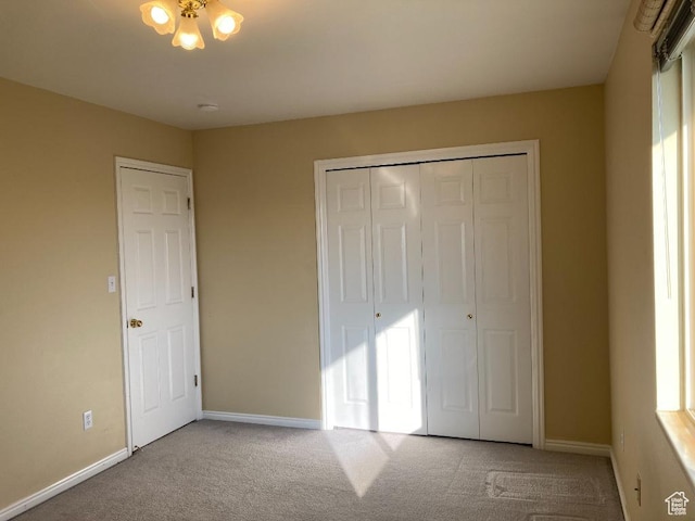 unfurnished bedroom with carpet flooring, baseboards, and a closet